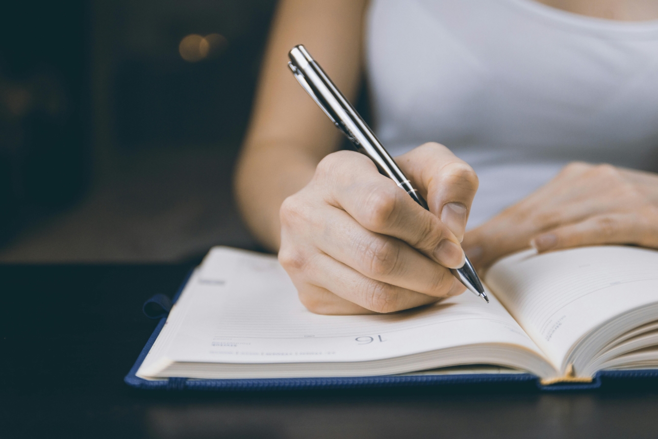 Person writing in notebook, symbolising ADHD coaching in Australia via telehealth with a Wellvue psychologist